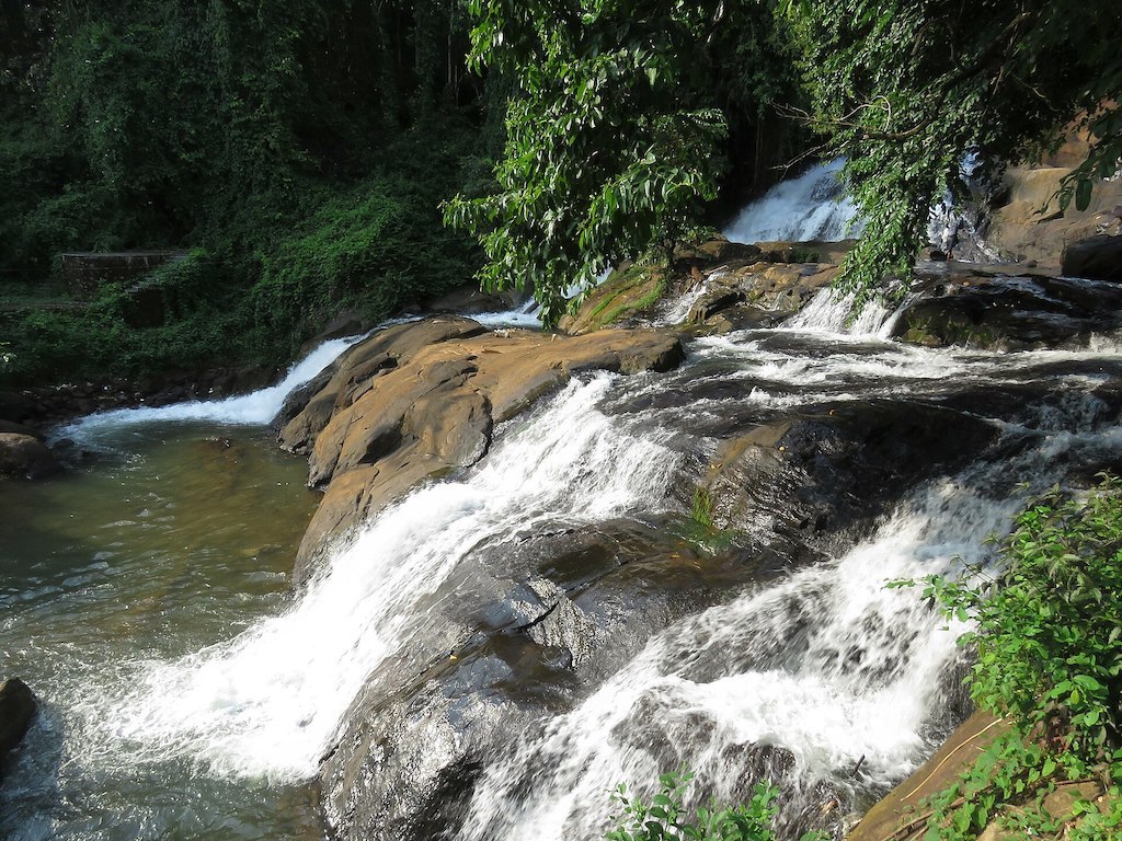 Aruvikkuzhi Waterfalls surrounded by greenery